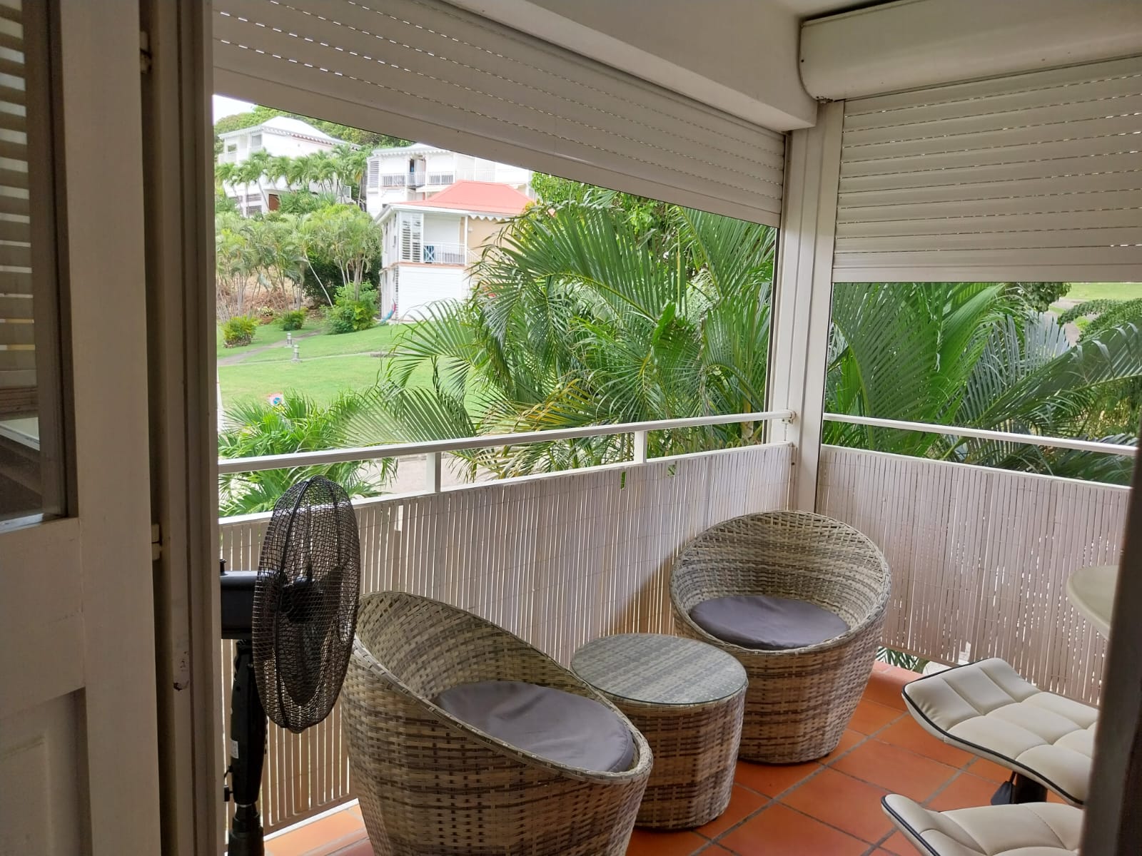 Balcon avec fauteuils en rotin et vue sur le jardin