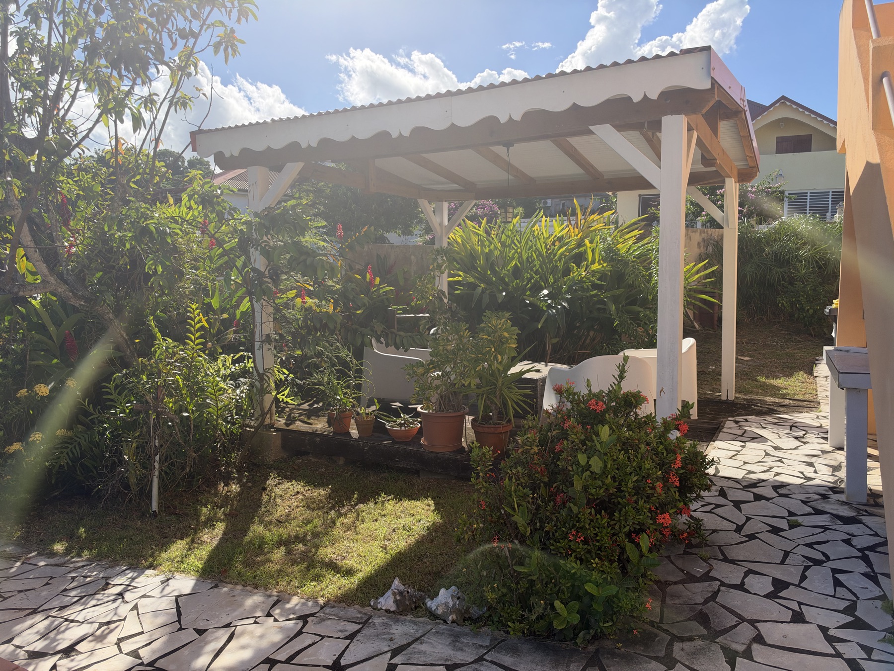 Carbet couvert au milieu du jardin tropical fleuri